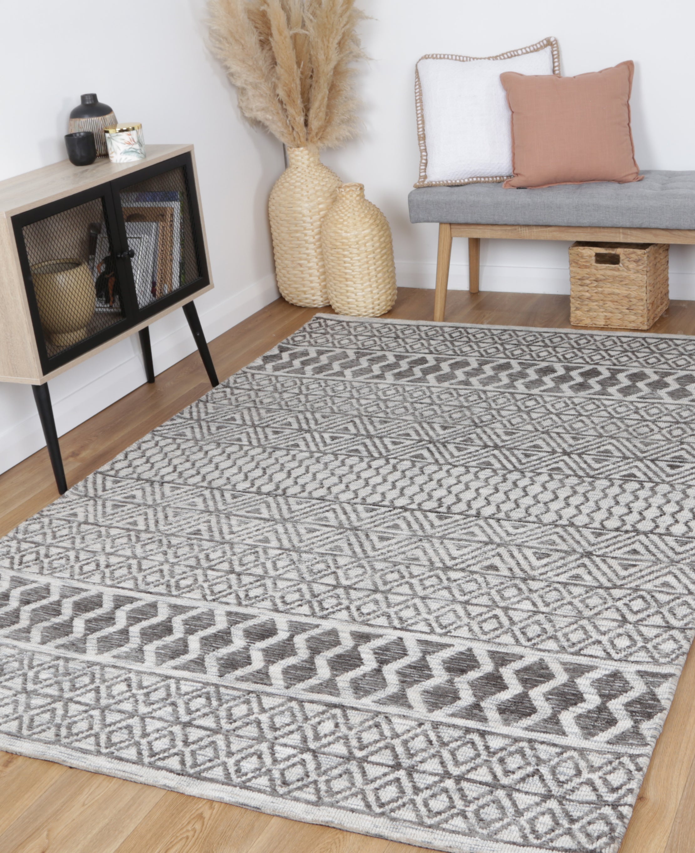 Alayah Tessellations grey & taupe Rug in livingroom with wicker furniture pink cushions and light flooring