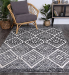 Alayah Diamond Grey Rug in living space with plants on grey floor boards