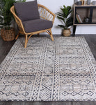 Alayah Tribal blue Rug in living room on dark flooring with wicker accessories